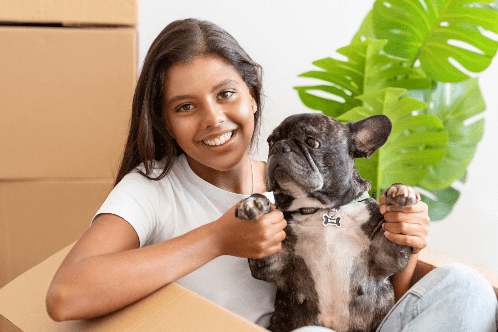 a woman and a frenchie in a box