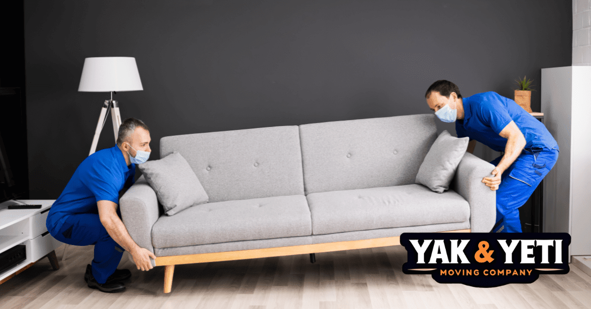 two men wearing face masks and sitting on a couch