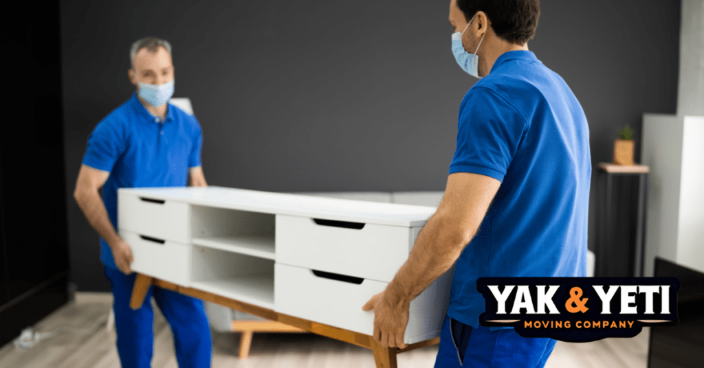 a couple of men wearing face masks holding a white shelf